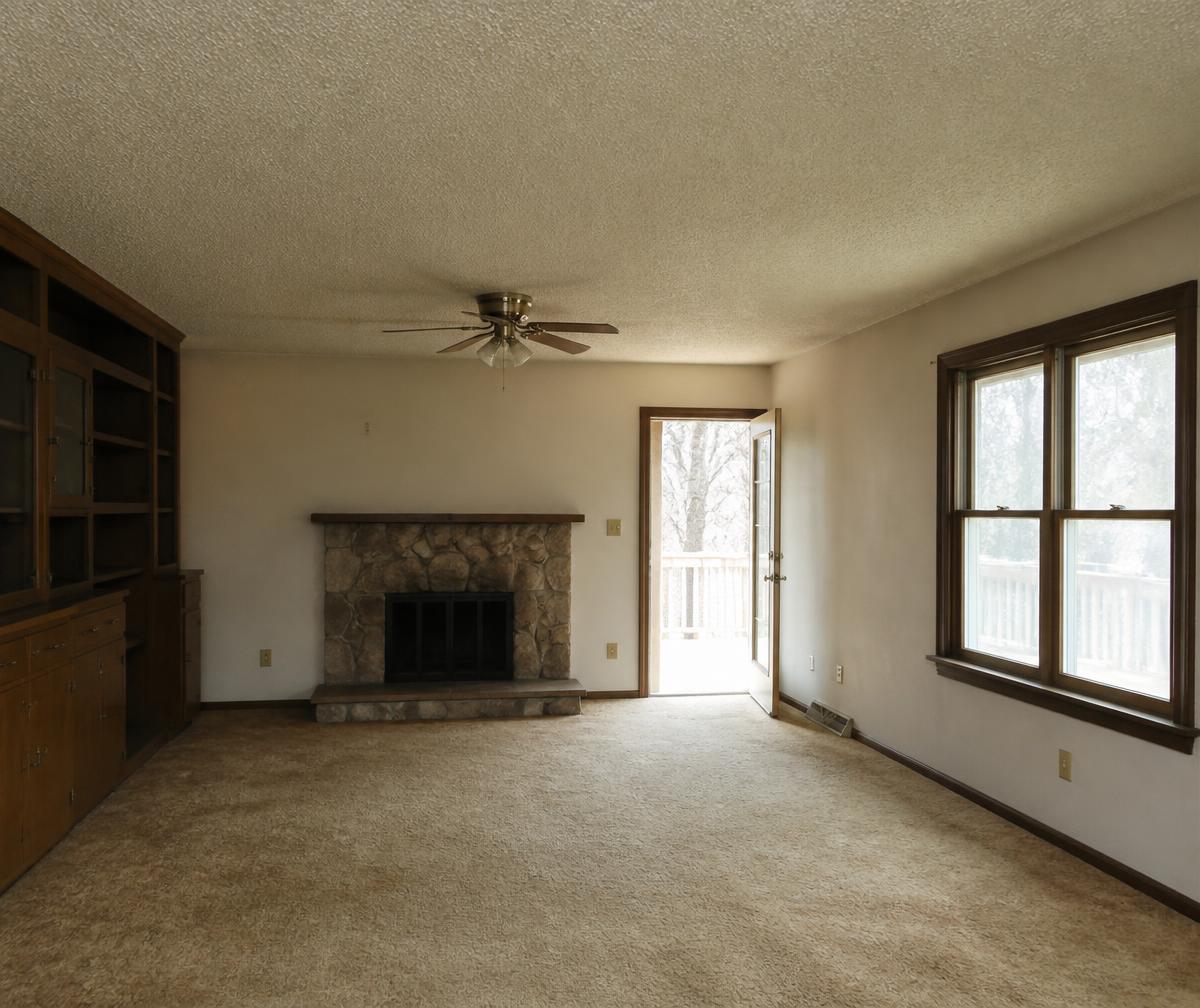 The same living room before renovation with dated carpet and trim