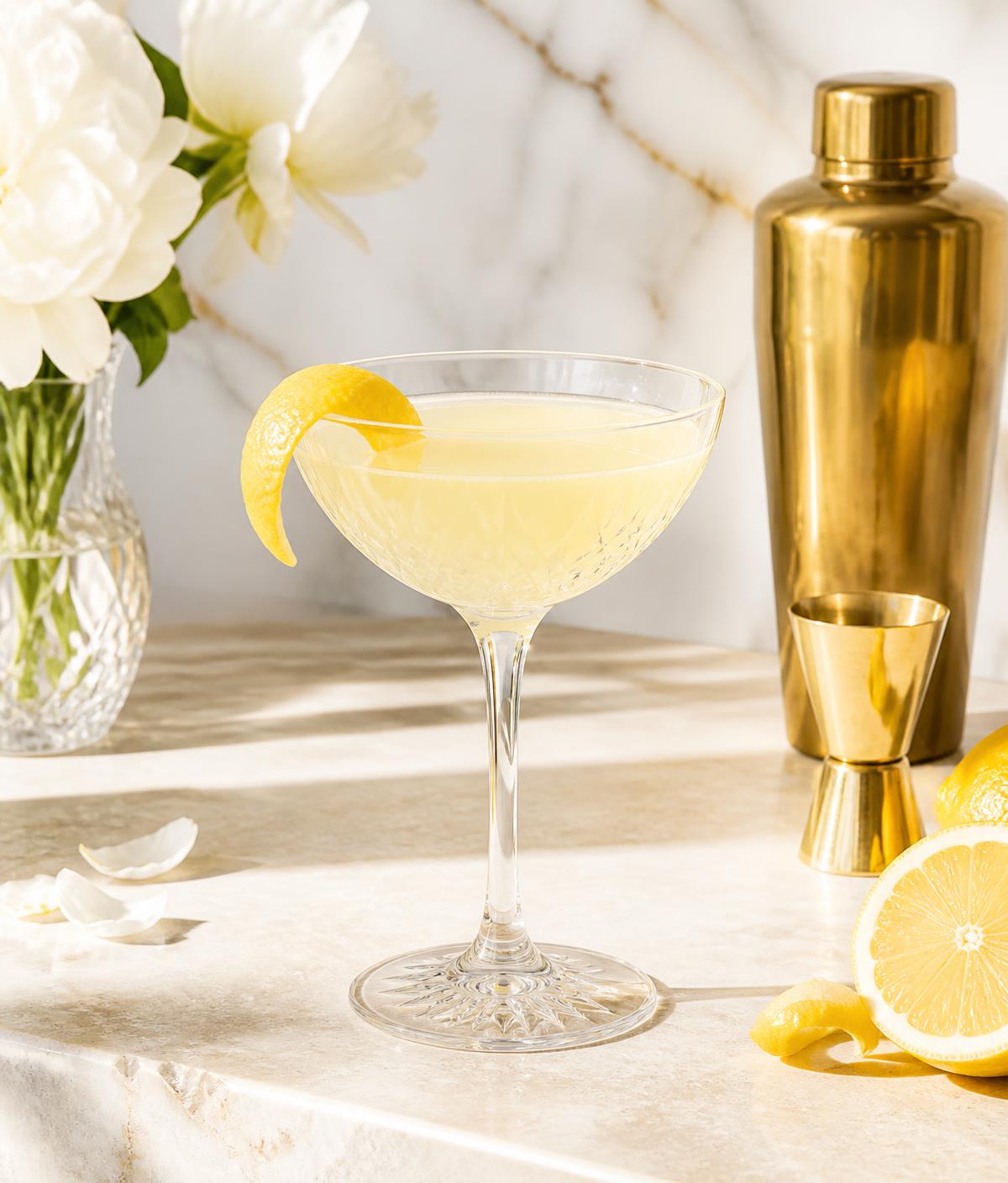 Citrus aperitif in a crystal coupe on a light stone bar
